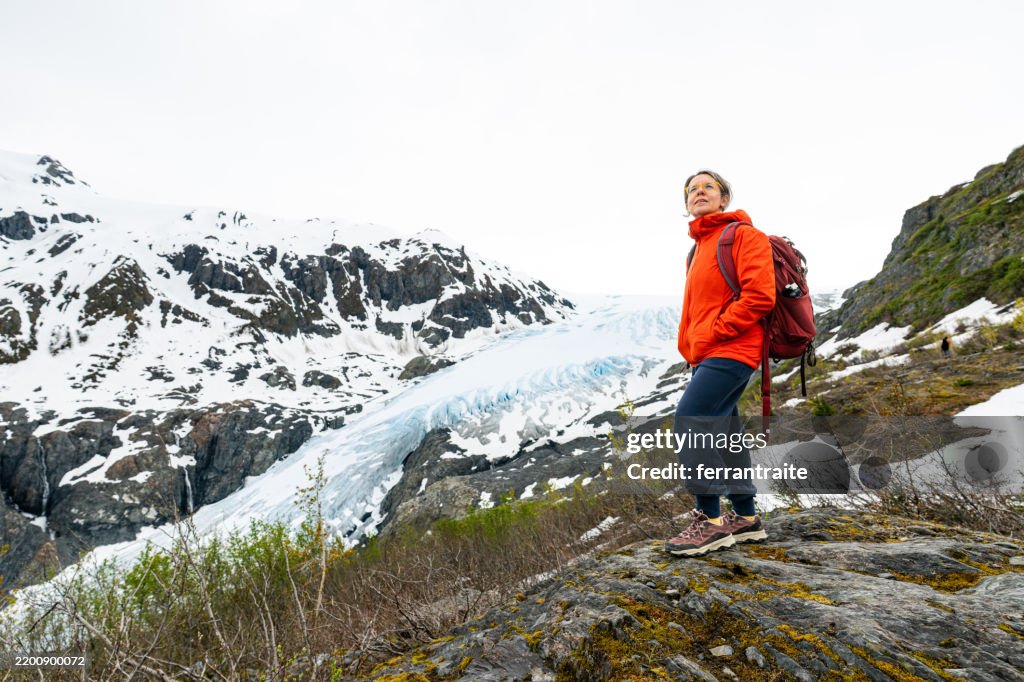 Mature female backpacker enjoying the view of a glacier
