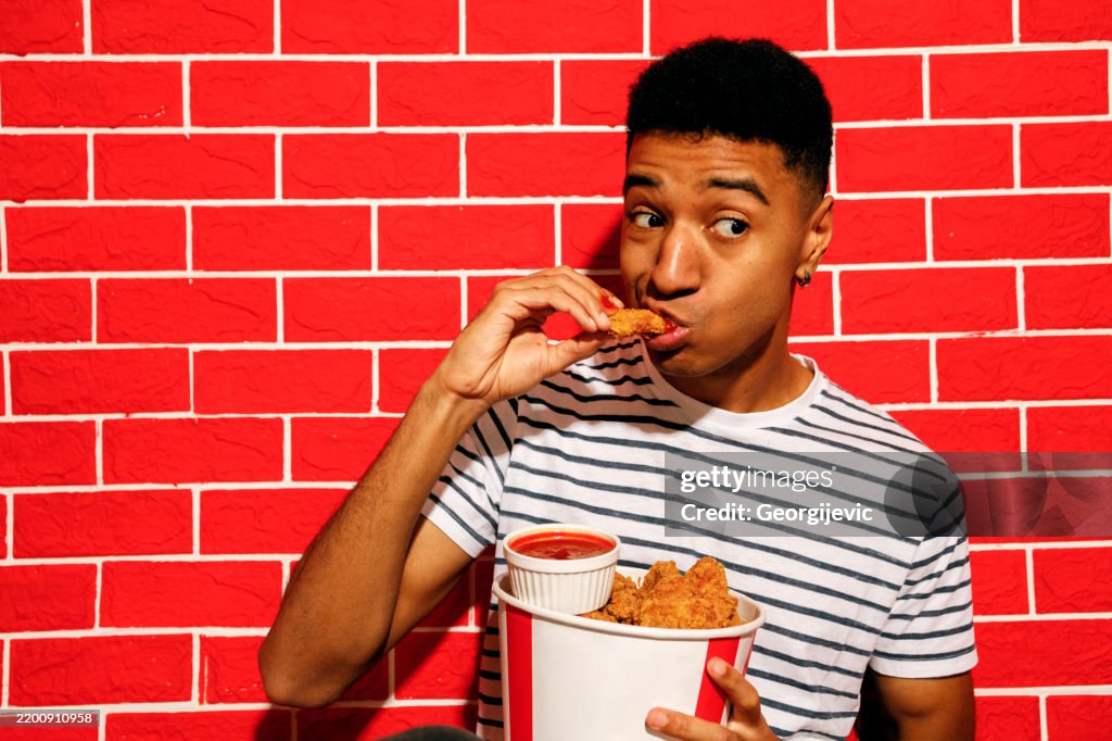 Young Man Enjoying Crispy Chicken