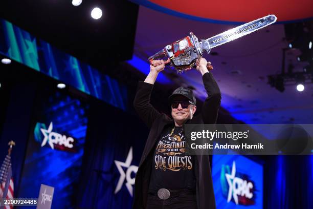 Of Tesla and SpaceX Elon Musk leaves the stage holding a chainsaw after speaking at the Conservative Political Action Conference at the Gaylord...