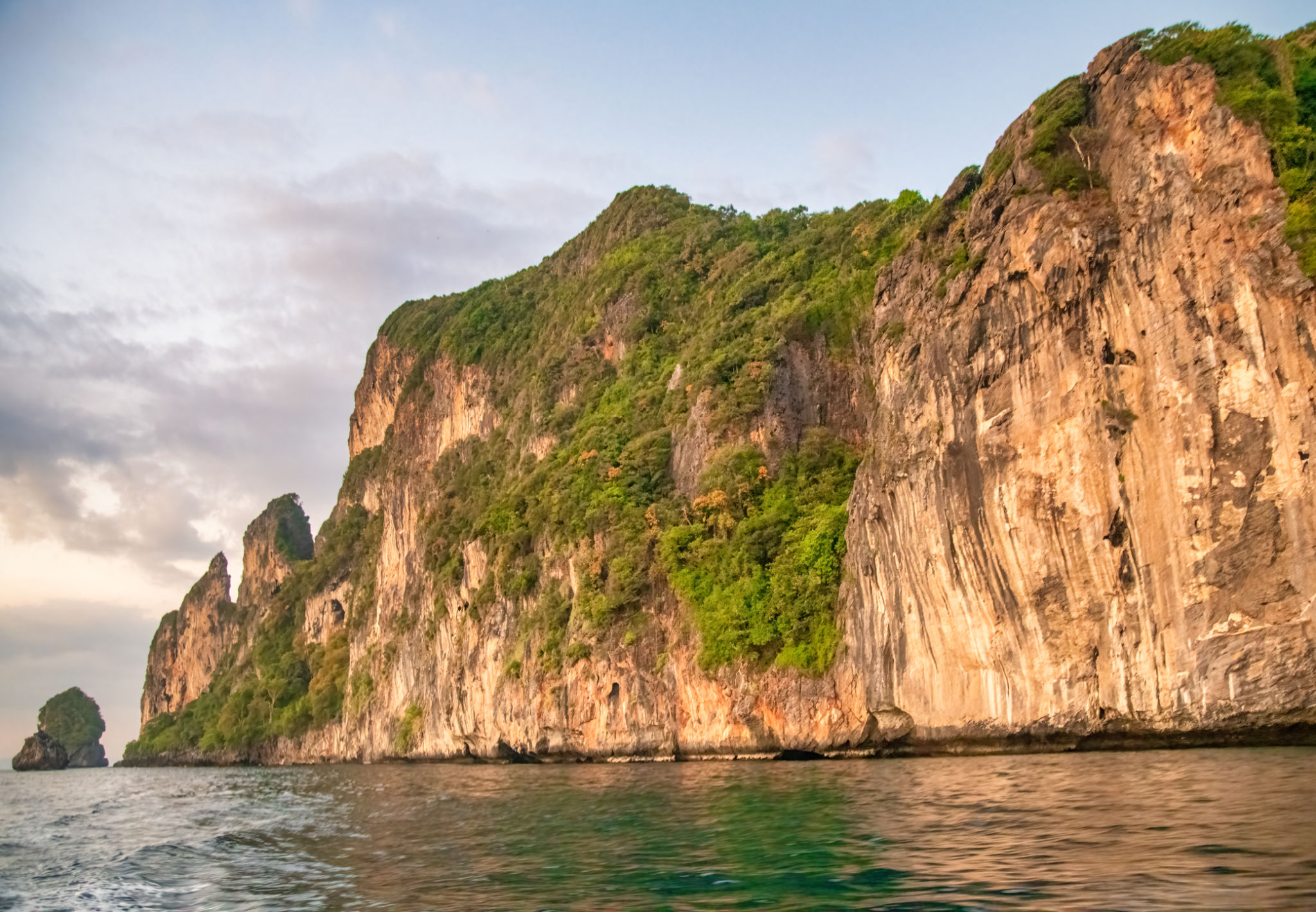 Long-tail boats silhouetted against a stunning sunset at Nui Beach, Phi Phi Don Long-tail boats silhouetted against a stunning sunset at Nui Beach, Phi Phi Don