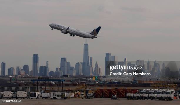 United Airlines airplane takes off at Newark Liberty International Airport in front of the skyline of lower Manhattan and One World Trade Center in...