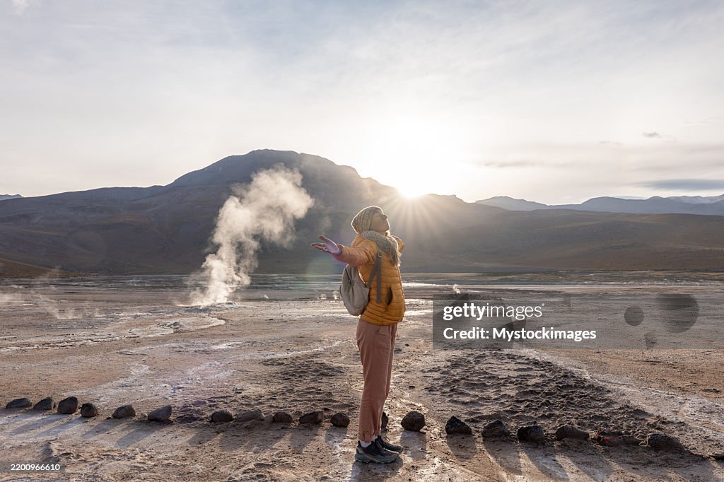 Mujer abrazando la naturaleza en el paisaje geotérmico