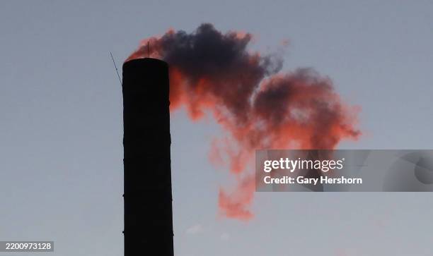 An emission comes out of a smoke stack on a building as the sun rises on February 18 in Hoboken, New Jersey.