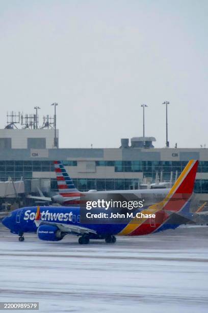 southwest airlines jet taxis during snowstorm, denver, colorado (usa) - southwest stock pictures, royalty-free photos & images