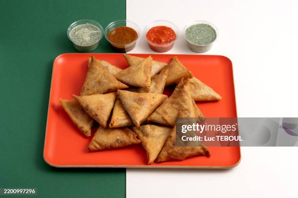samosas on a platter with accompanying sauces - samosa stock pictures, royalty-free photos & images