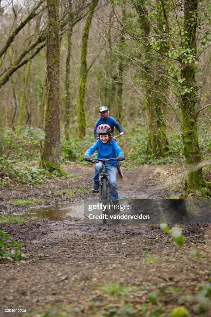 Two young boys enjoying a woodland bike ride