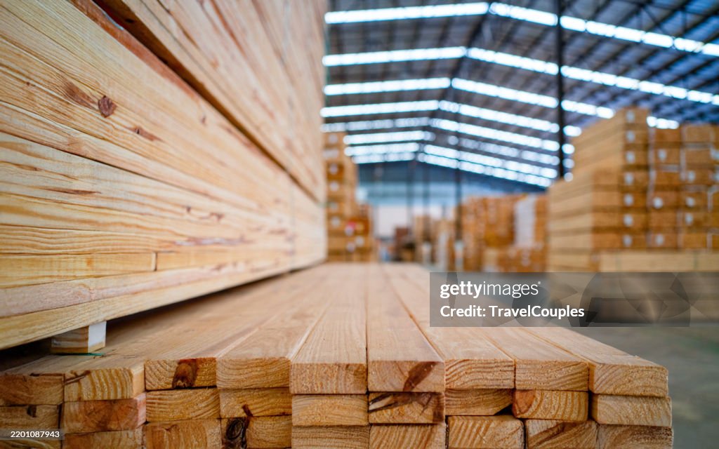 Stacked lumber. Folded wood. Closeup wooden boards. The surface of the end of the board. Lots of planks stacked on top of each other in the warehouse. Lumber for use in construction