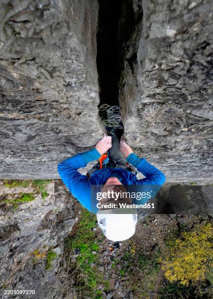 determined rock climber climbing cliff - risk stock pictures, royalty-free photos & images