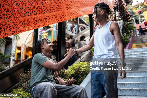 young friends greeting outdoors - afro caribbean hairstyles stock pictures, royalty-free photos & images
