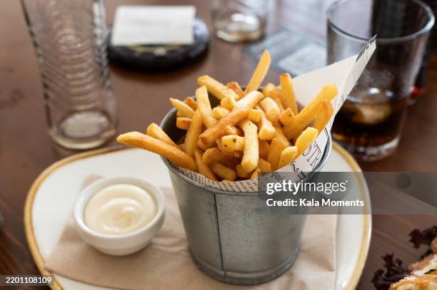 french fries with mayonnaise served in metal bucket during summer holiday - mayonaise stockfoto's en -beelden