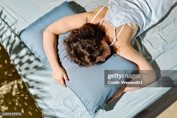 woman sleeping on bed at home - pillow stock pictures, royalty-free photos & images