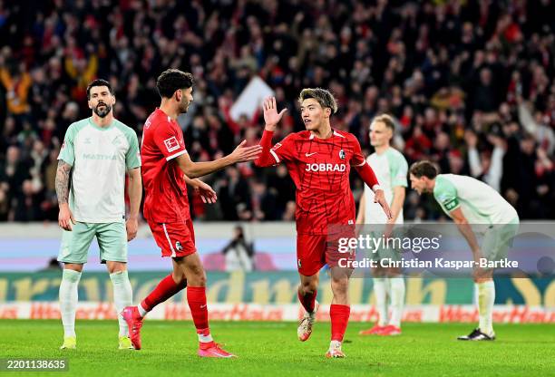 Ritsu Doan of SC Freiburg celebrates scoring his team's fourth goal with teammate Eren Dinkci during the Bundesliga match between Sport-Club Freiburg...