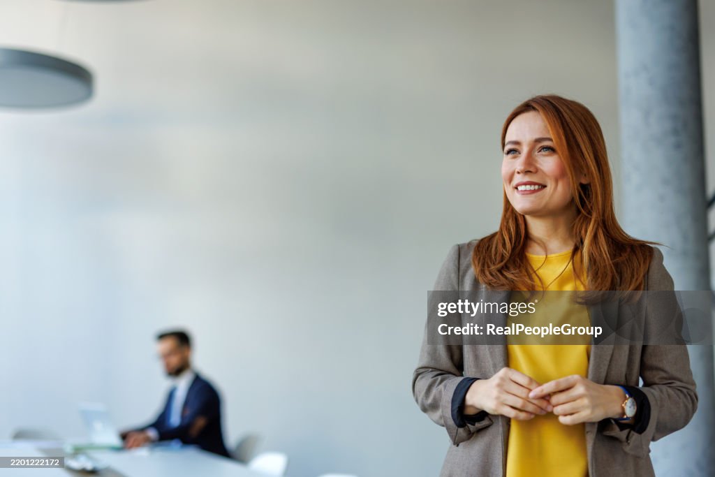 Young businesswoman smiling in modern office with copy space