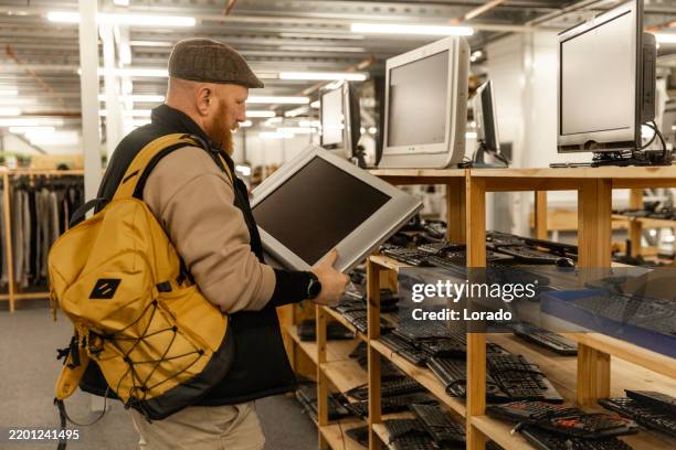 redhead senior man looking through the electronics in a public second hand store - old electronics stock pictures, royalty-free photos & images