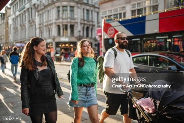 gruppe von freunden bei einem spaziergang durch die straßen von london. - high street stock-fotos und bilder