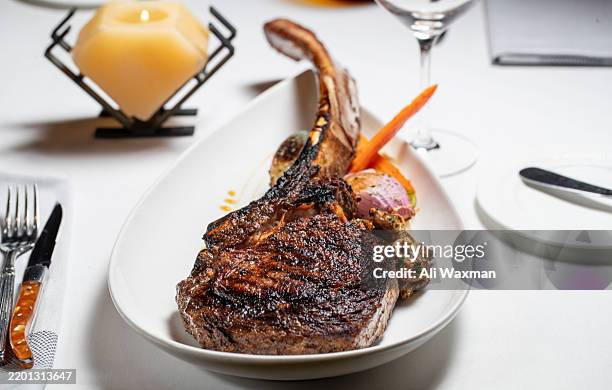 delicious tomahawk steak over potatoes purée in a fine dining restaurant - tomahawk stock pictures, royalty-free photos & images