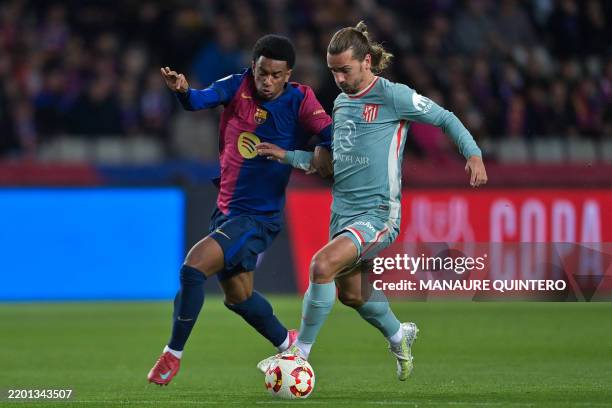 Atletico Madrid's French forward Antoine Griezmann is challenged by Barcelona's Spanish defender Alex Balde before scoring their second goal during...