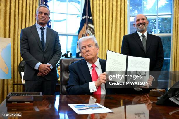 President Donald Trump holds an Executive Order, alongside US Secretary of Health and Human Services Robert F. Kennedy Jr. And US Secretary of...