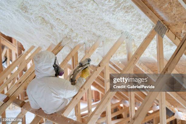 construction worker spraying house insulation - spray insulation stock pictures, royalty-free photos & images