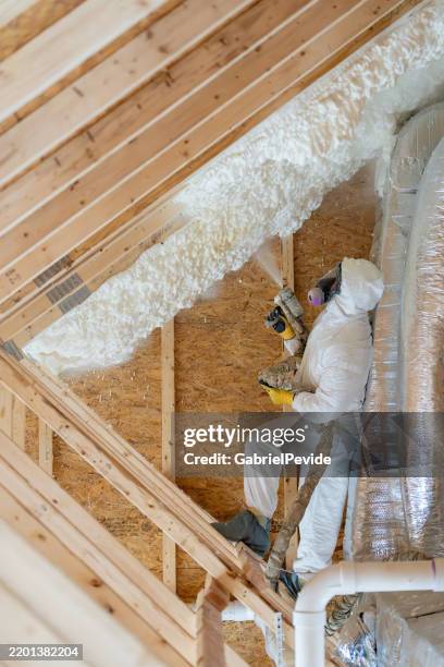 construction worker spraying house insulation - attic stock pictures, royalty-free photos & images