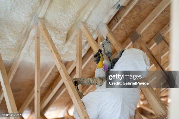 construction worker spraying house insulation - spray insulation stock pictures, royalty-free photos & images