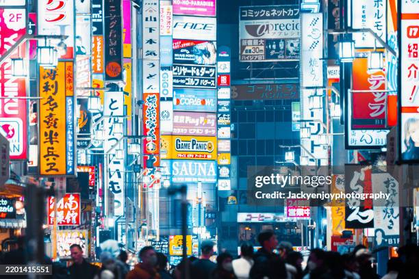 people crossing the street at night at tokyo's kabukicho entrance - prefettura di tokyo foto e immagini stock