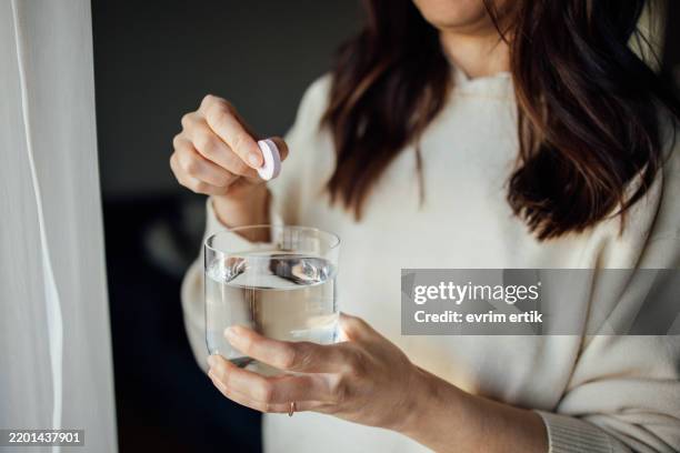 tomar la tableta efervescente de mujer - disolver fotografías e imágenes de stock
