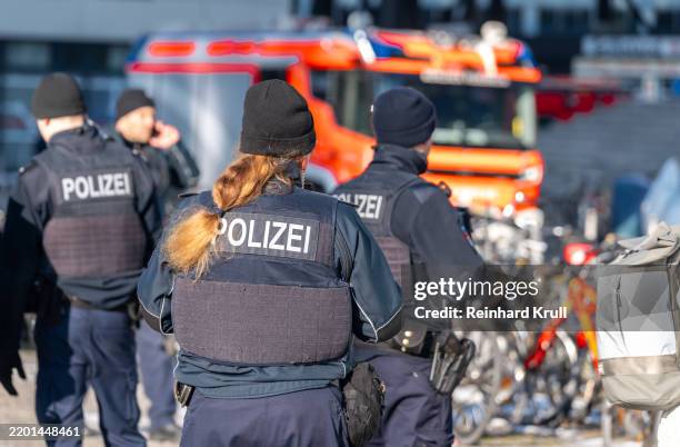rückansicht von polizisten vor einem feuerwehrfahrzeug - feuerwehr deutschland stock-fotos und bilder
