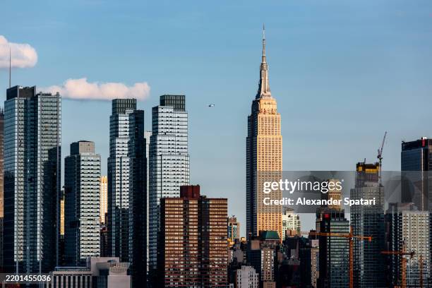 manhattan skyline with empire state building on a sunny day with clear blue sky, new york city, usa - empire state building stock-fotos und bilder