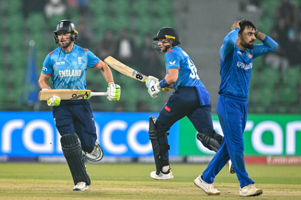 England's captain Jos Buttler and his teammate Joe Root run between the wickets as Afghanistan's Rashid Khan gestures during the ICC Champions Trophy...