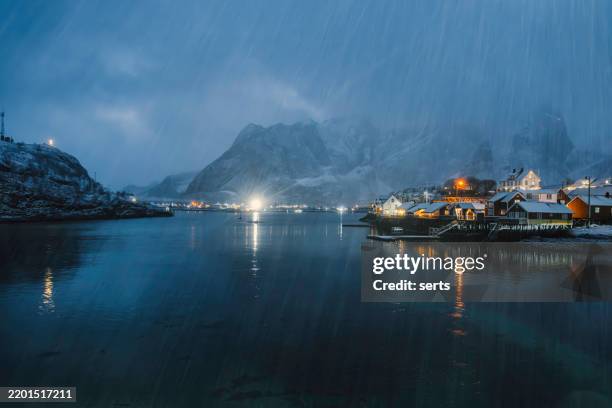 snowfall at night over sakrisoy fishing village in lofoten, norway - fishing village stock pictures, royalty-free photos & images