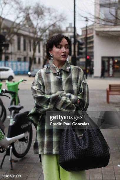 Guest is seen wearing a green plaid shirt with a pair of pastel green jogging bottoms outside the Charlie Constantinou during London Fashion Week...