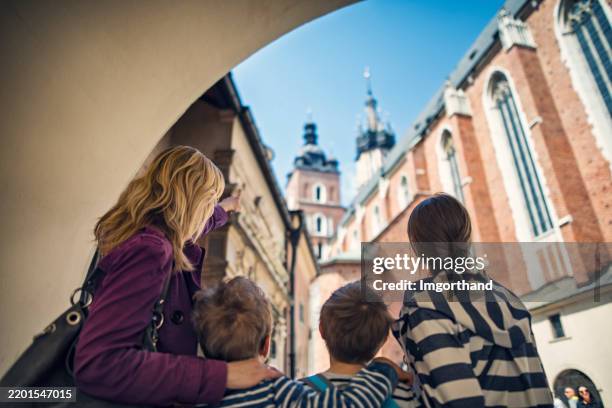 family exploring courtyard behind the st. mary's church in cracow - krakow stock pictures, royalty-free photos & images