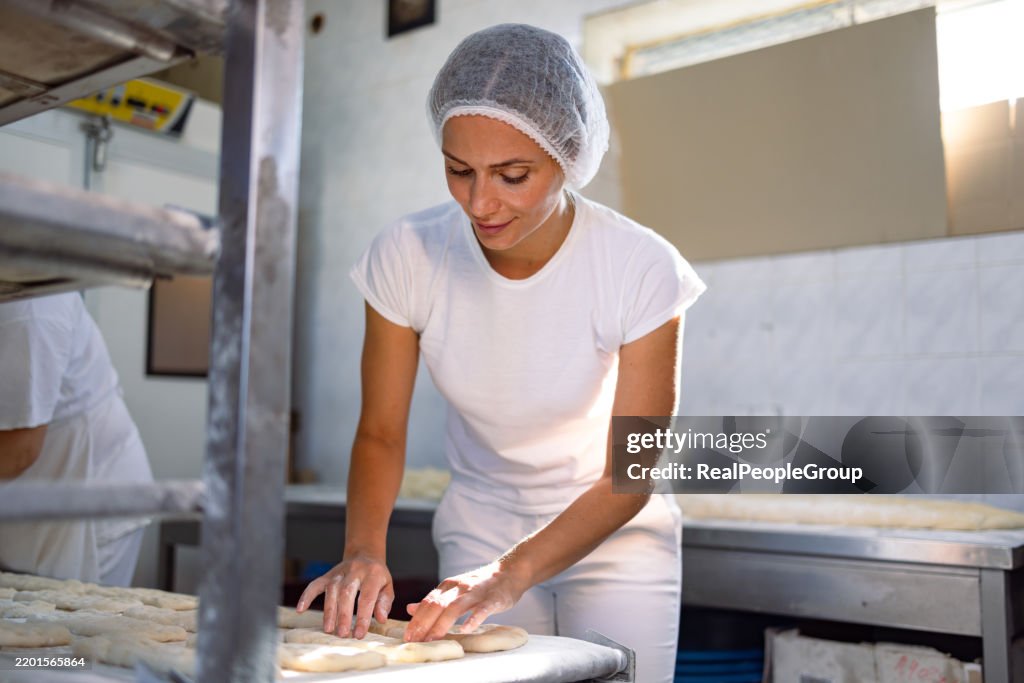 Baker preparing loaves in bakery
