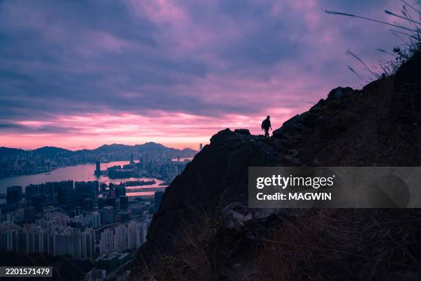 backpacker hiking mountain ridge with view of kowloon peak / fei ngo shan - person standing on mountain above city stock pictures, royalty-free photos & images