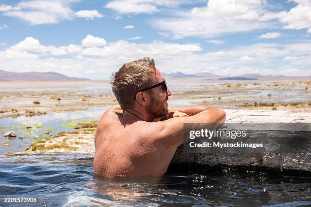 homme se relaxant dans une source chaude extérieure - piscine thermale photos et images de collection