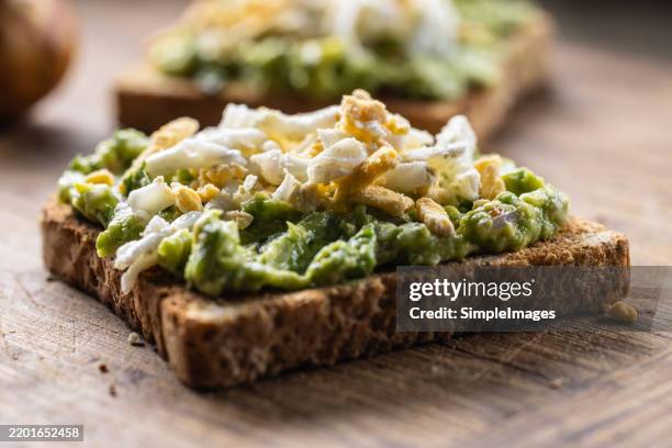 guacamole spread on toasted bread with egg. - vegetable spread stock pictures, royalty-free photos & images