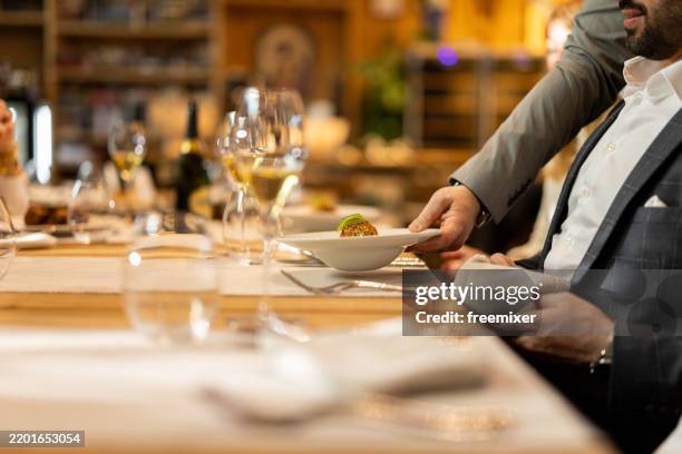 groupe de personnes dînant dans un restaurant de luxe - table dressée photos et images de collection