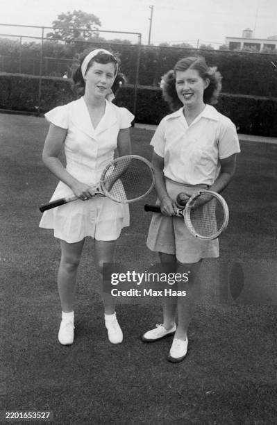 American tennis players Barbara Scofield and Dorothy Head posing in tennis outfits, circa 1950. Scofield is wearing a short tennis dress while Head...
