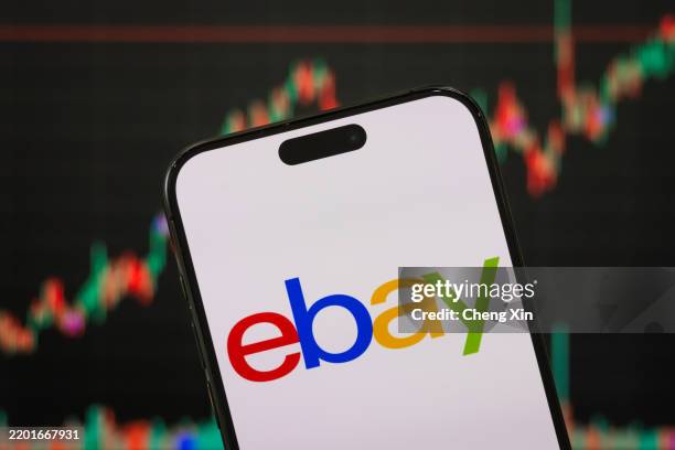 In this photo illustration, the eBay logo is displayed on a smartphone screen, with the company's latest stock market performance and candlestick...