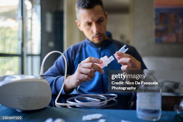 man assembling nebulizer components for aerosol treatment - bronchitis stock pictures, royalty-free photos & images