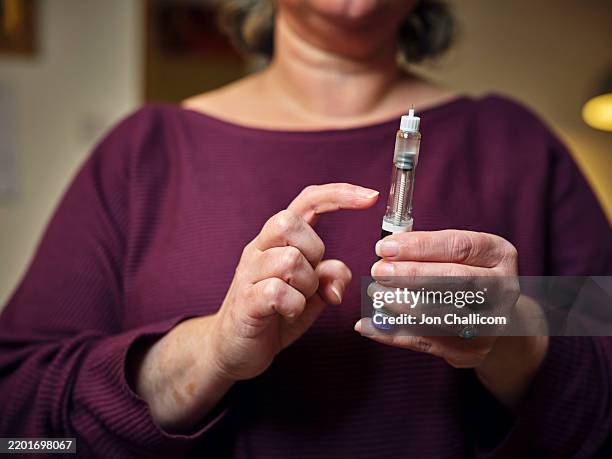 a woman prepares for a subcutaneous self-injection with a semaglutide pen 'diet drug' . the modern wonder weight loss drug and diabetes treatment highlights a personal healthcare routine at home. - fazer dieta imagens e fotografias de stock