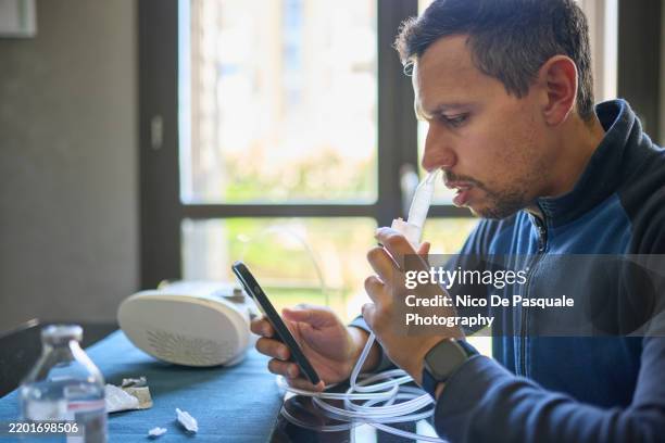 man using compressor nebuliser for aerosol treatment at home - cellular respiration stock pictures, royalty-free photos & images