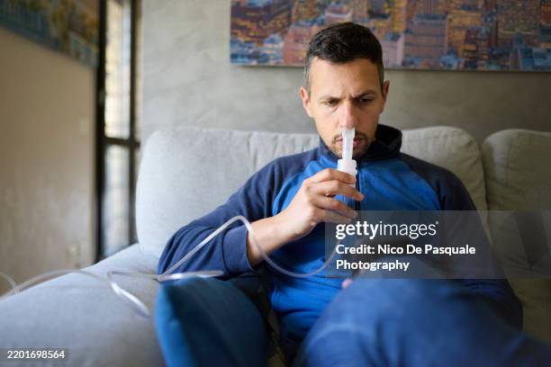 man using compressor nebuliser for aerosol treatment at home - cellular respiration stock pictures, royalty-free photos & images