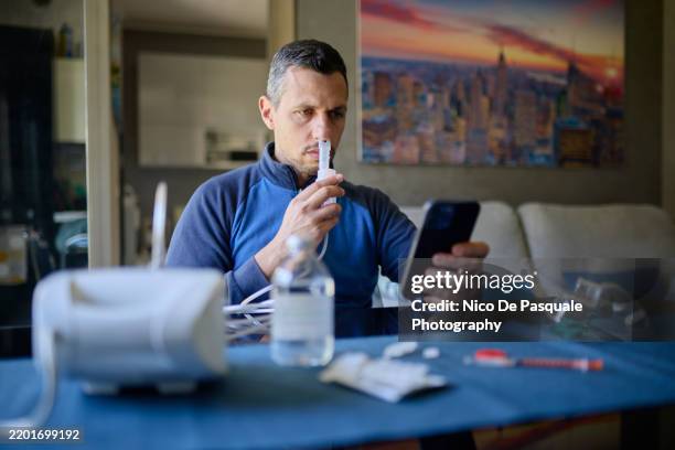 man using compressor nebuliser for aerosol treatment at home - cellular respiration stock pictures, royalty-free photos & images