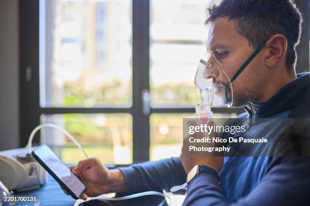 man using compressor nebuliser for aerosol treatment at home - cellular respiration stock pictures, royalty-free photos & images