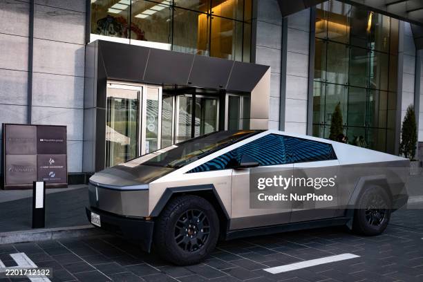 Tesla Cybertruck parks in front of the International Finance Center Seoul in the Yeouido financial district as a pedestrian walks past on February 27...