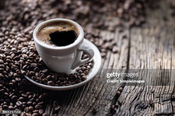 cup of black coffee with coffee beans on old wooden table - coffee bildbanksfoton och bilder