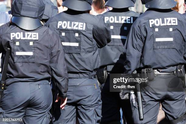 team of four fully equipped and protected german police officers in action - cultura alemana fotografías e imágenes de stock