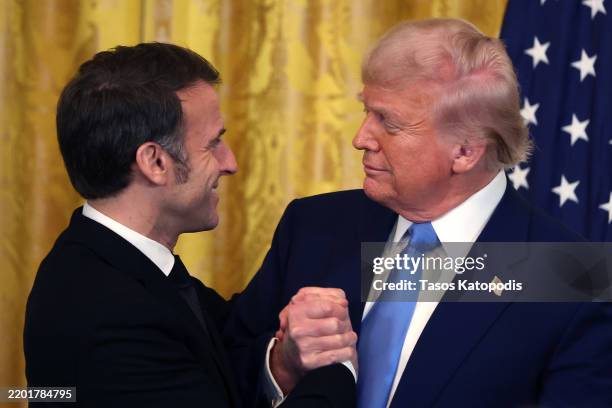 President Donald Trump and French President Emmanuel Macron embrace during a joint press conference in the East Room at the White House on February...